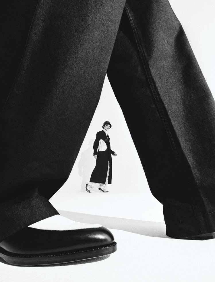 Tiny figure between giant legs in studio